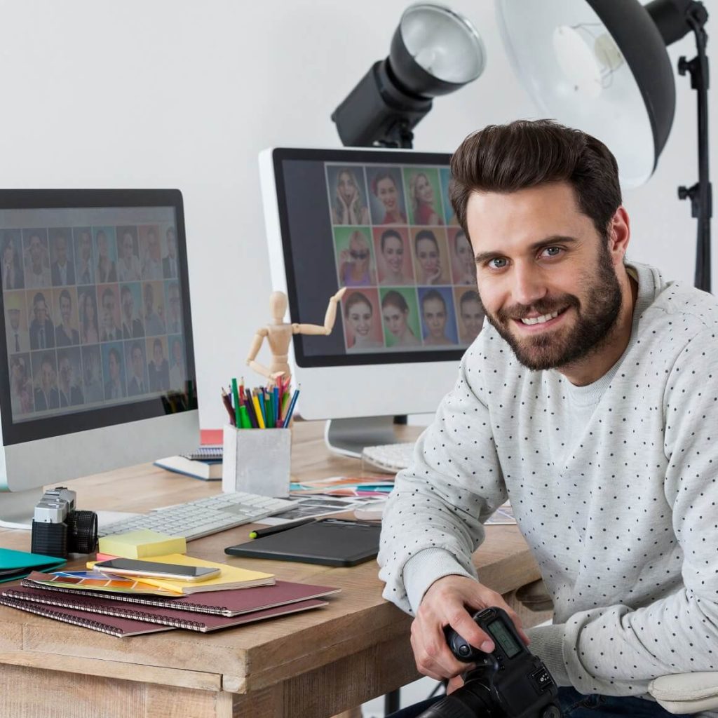 happy photographer holding camera at his desk 9reyfmz.jpg